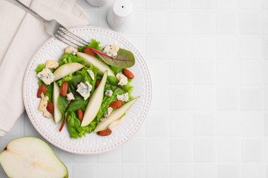 Photo of Delicious pear salad served on white tiled table, flat lay. Space for text