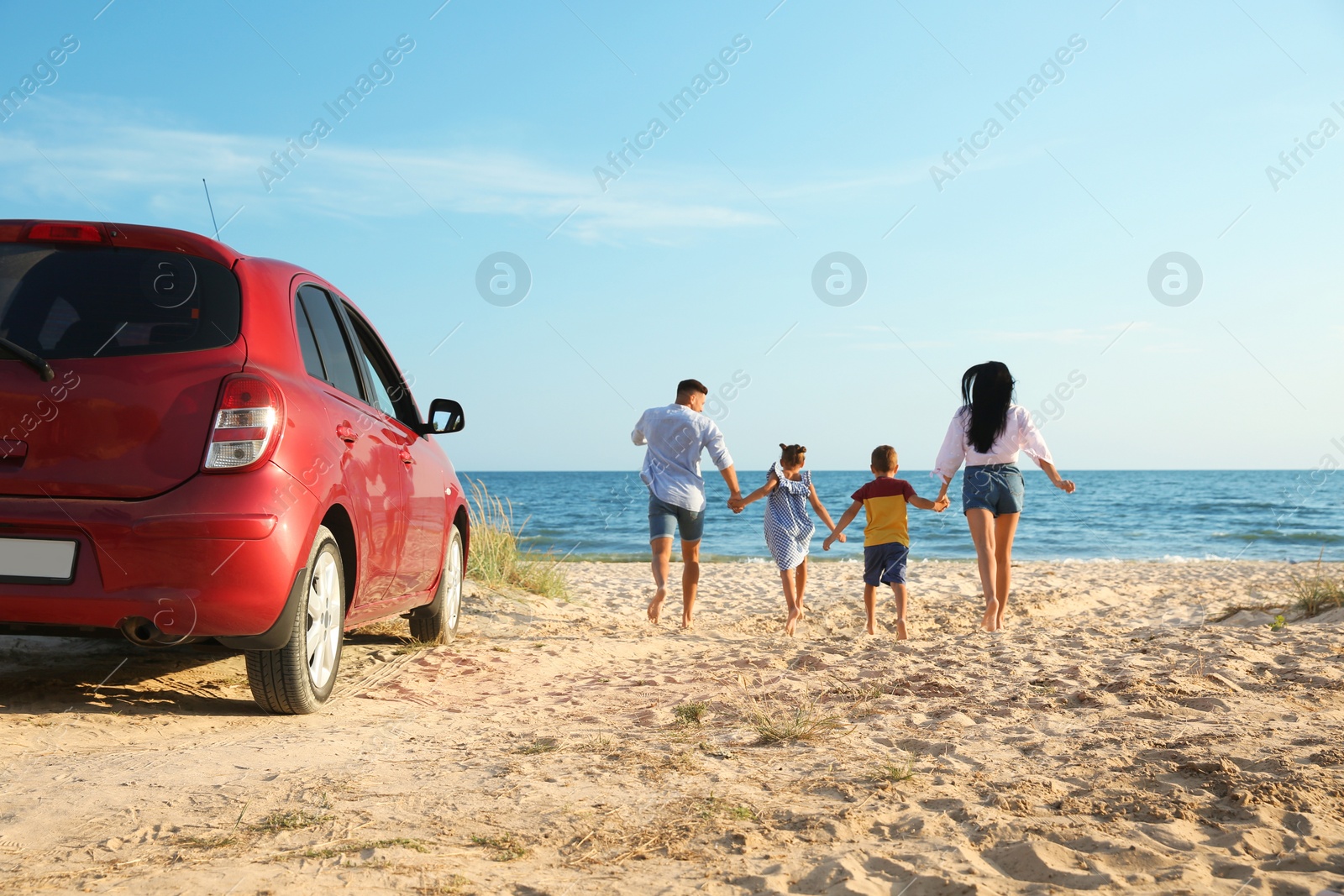 Photo of Family running on sandy beach. Summer trip
