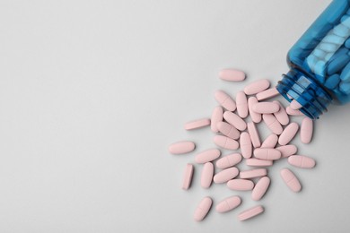 Vitamin pills and bottle on grey background, top view. Space for text