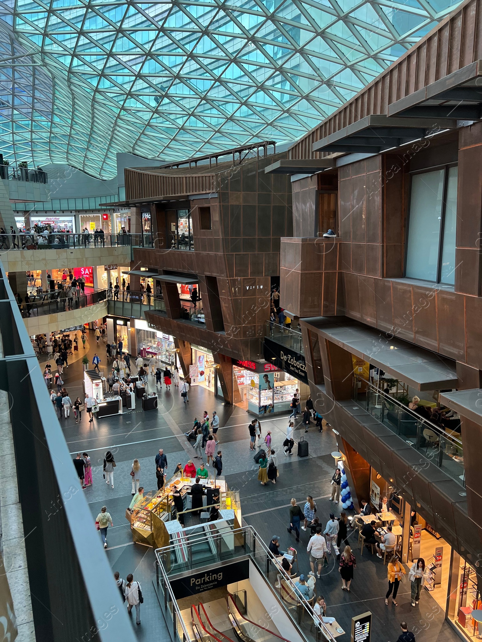 Photo of WARSAW, POLAND - JULY 17, 2022: Big shopping mall with many stores and customers