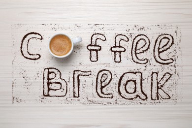 Photo of Phrase Coffee Break made with cup of drink and powder on light wooden table, flat lay