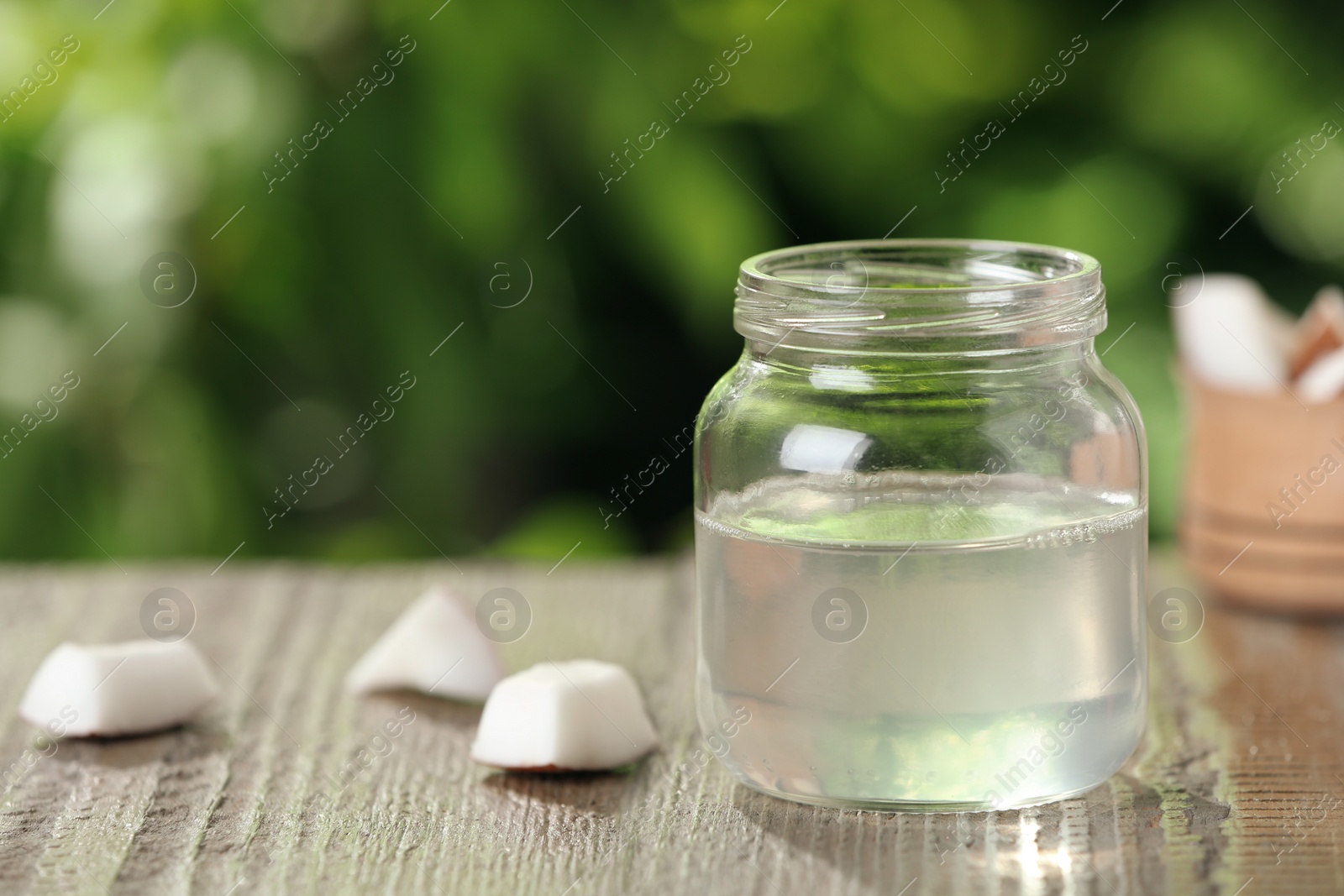 Photo of Coconut oil on wooden table, space for text