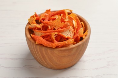 Photo of Dry orange peels in bowl on wooden table