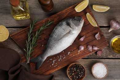 Photo of Flat lay composition with raw dorado fish and spices on wooden table