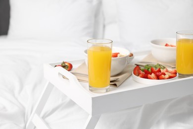 Photo of White tray with tasty breakfast on bed