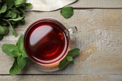 Photo of Cup of hot aromatic tea with mint on wooden table, flat lay. Space for text