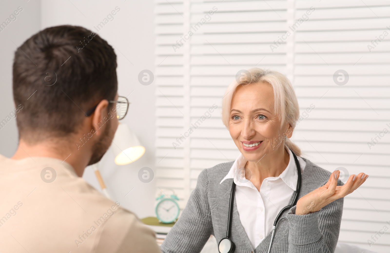 Photo of Professional female doctor consulting patient in clinic