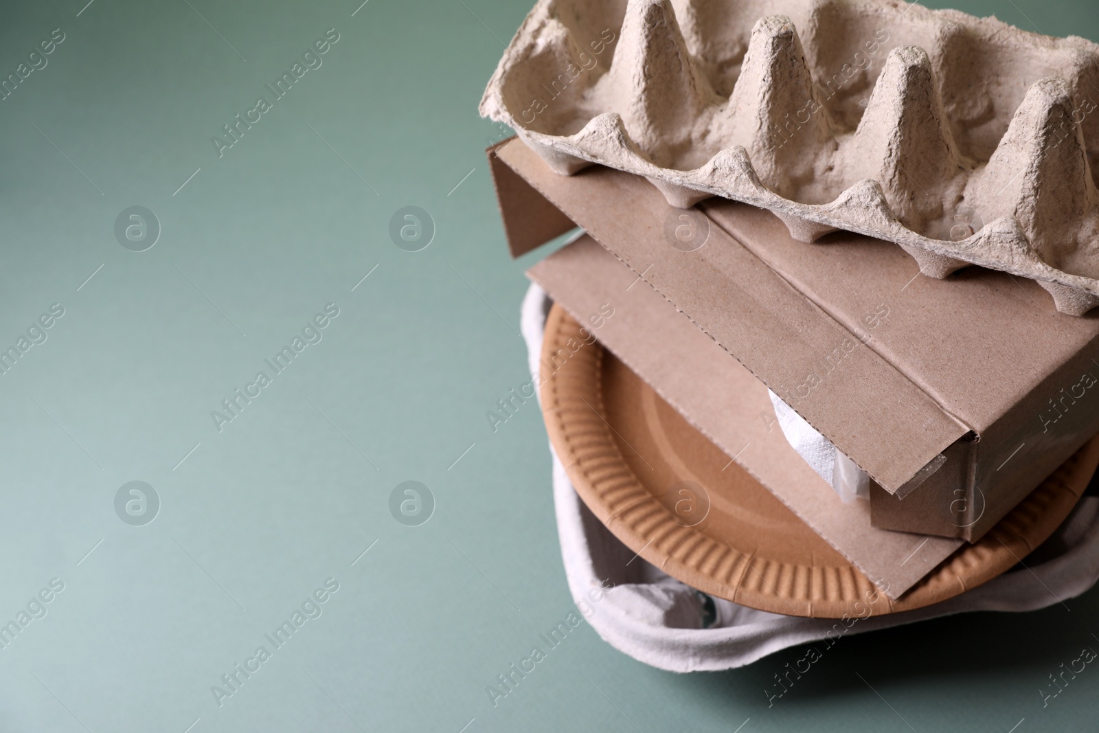 Photo of Stack of waste paper on grey table, closeup. Space for text