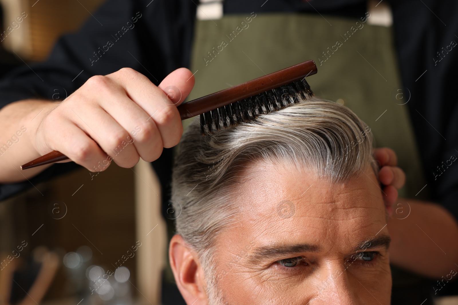 Photo of Hair styling. Professional hairdresser working with client in barbershop, closeup