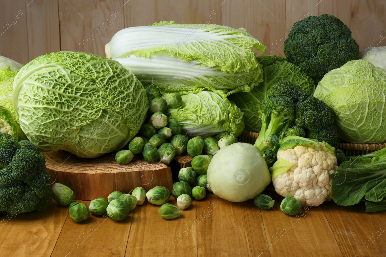 Photo of Many different types of fresh cabbage on wooden table