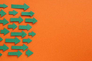 Photo of Paper arrows on orange background, flat lay. Space for text
