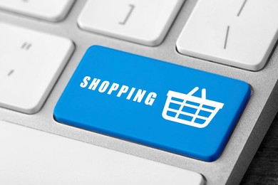Image of Online store purchase. Light blue button with word Shopping and basket on computer keyboard, closeup
