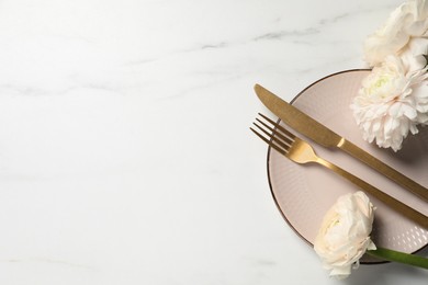 Photo of Stylish table setting with cutlery and flowers on white marble background, flat lay. Space for text