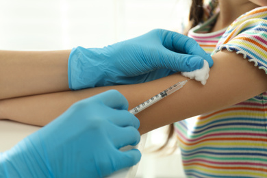 Photo of Doctor vaccinating little child in clinic, closeup