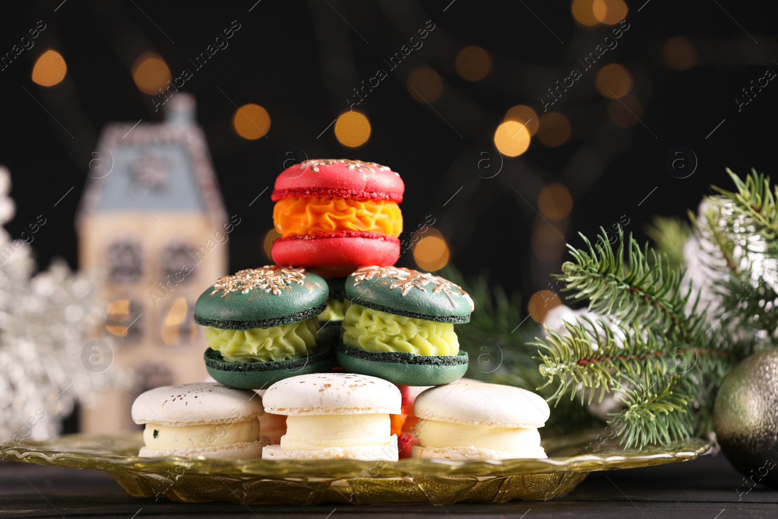 Photo of Beautifully decorated Christmas macarons and fir branches against blurred lights