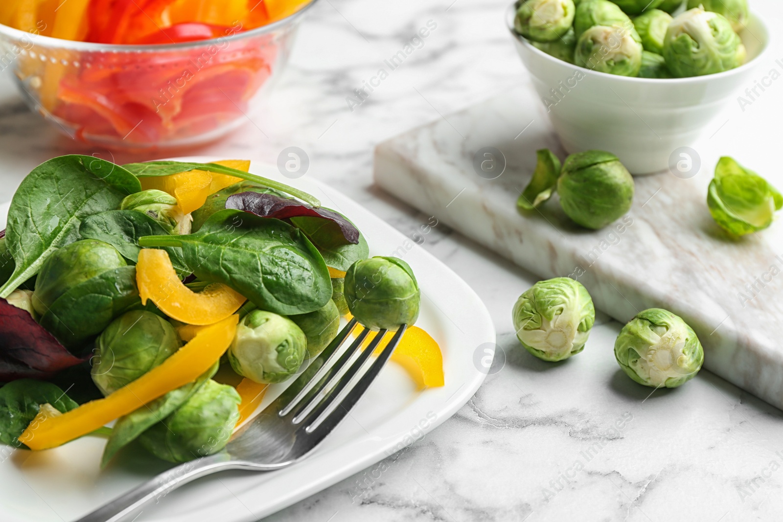 Photo of Tasty salad with Brussels sprouts served on white marble table, closeup