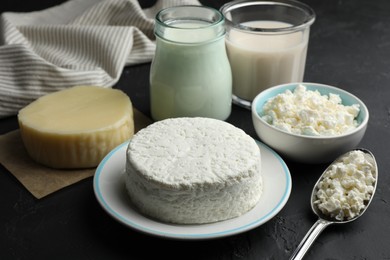 Photo of Many different lactose free dairy products on black textured table, closeup