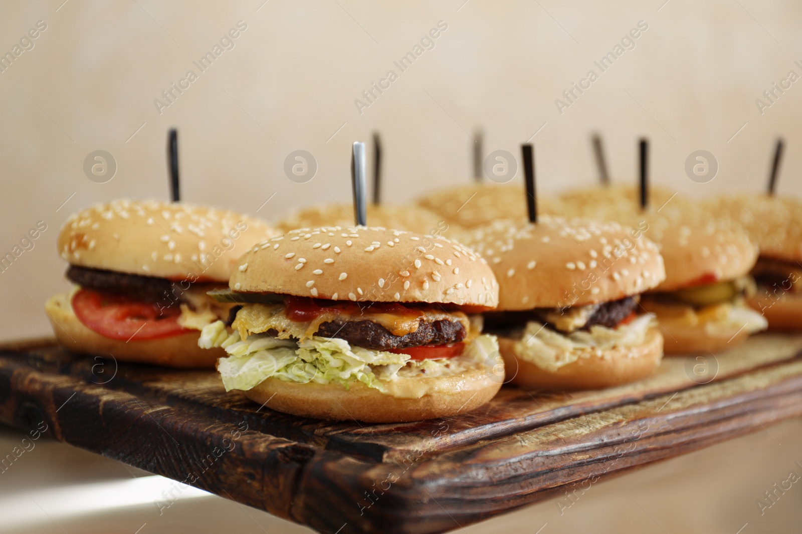 Photo of Tasty burgers on wooden board in school canteen. Fresh food