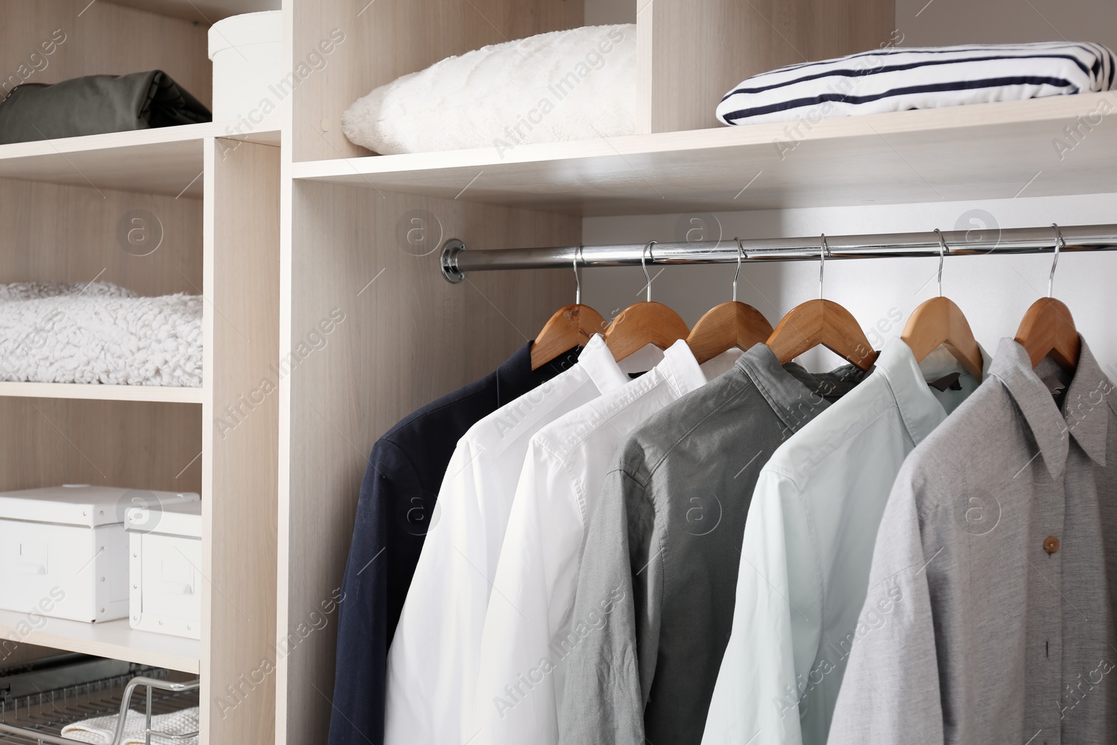 Photo of Stylish clothes and home stuff in large wardrobe closet