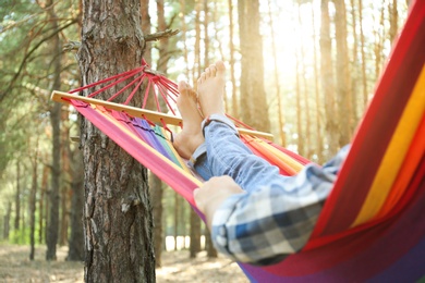 Photo of Man resting in hammock outdoors on summer day, closeup of legs