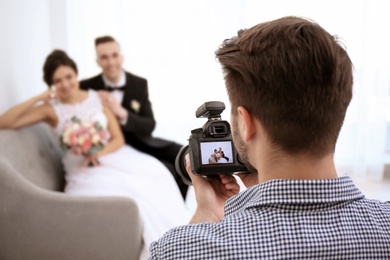 Photo of Professional photographer taking photo of wedding couple in studio