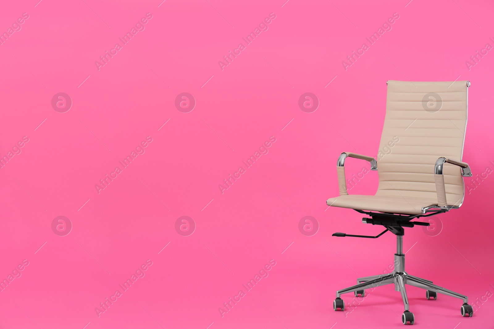 Photo of Comfortable office chair on pink background, space for text