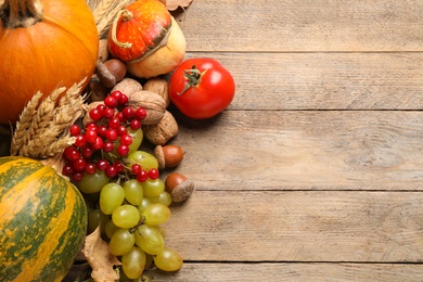 Photo of Flat lay composition with autumn vegetables and fruits on wooden background, space for text. Happy Thanksgiving day