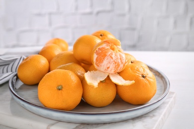 Photo of Fresh tangerines on white table. Citrus fruit