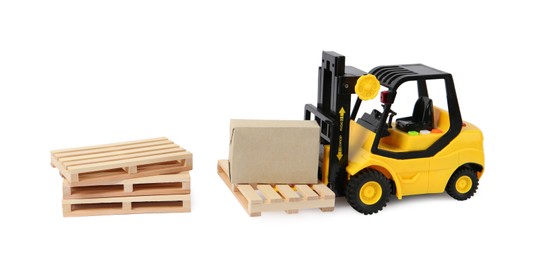 Photo of Toy forklift, wooden pallets and box on white background
