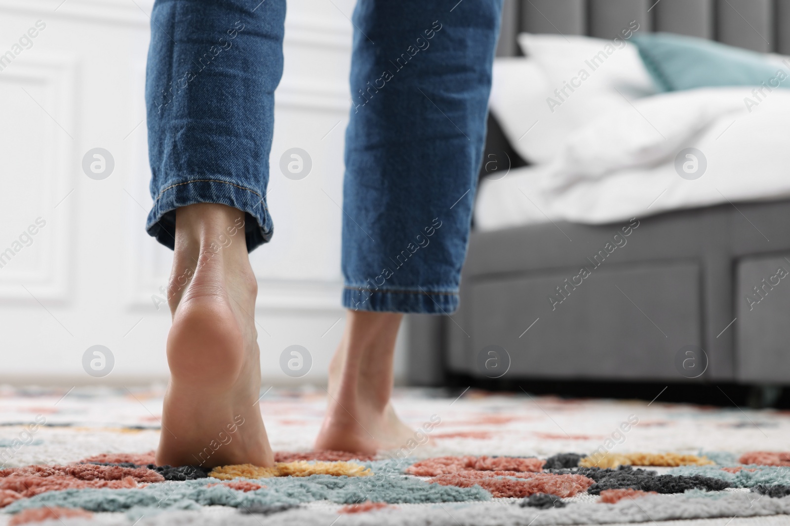 Photo of Woman walking on carpet with pattern at home, closeup. Space for text