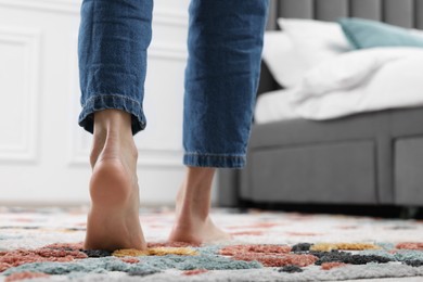 Photo of Woman walking on carpet with pattern at home, closeup. Space for text