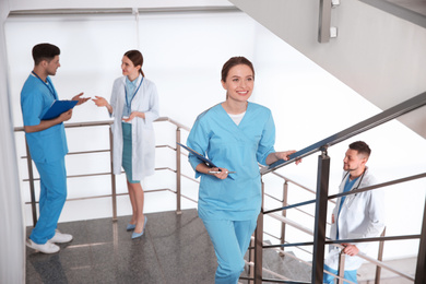 Photo of Female doctor going upstairs in modern clinic