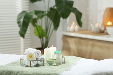 Composition with different spa products and burning candles on table indoors. Space for text