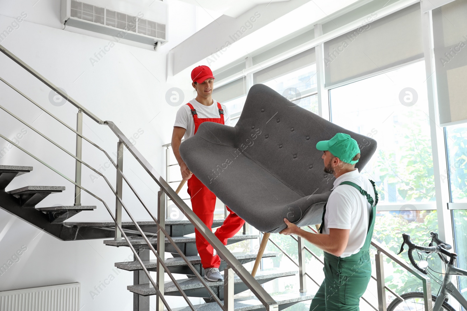 Photo of Male movers carrying sofa in new house