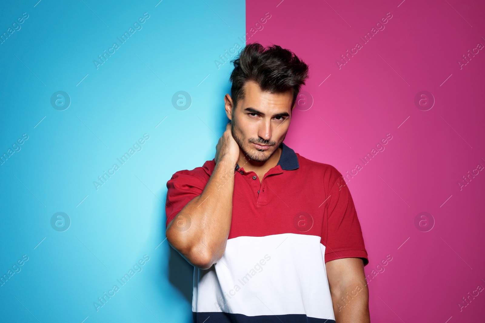 Photo of Young man with trendy hairstyle posing on color background