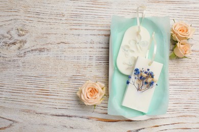 Flat lay composition with scented sachets on white wooden table, space for text