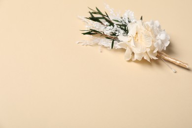 Stylish boutonniere on beige background, closeup. Space for text