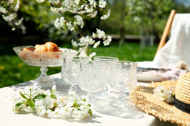 Photo of Beautiful table setting with spring flowers in garden on sunny day