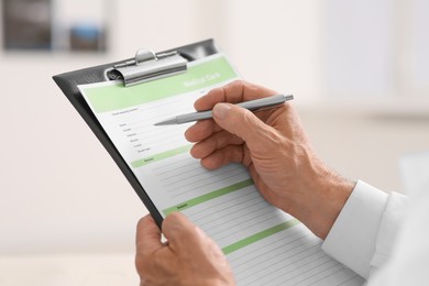 Photo of Doctor filling patient's medical card in clinic, closeup