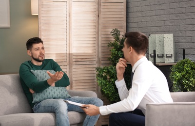 Male psychologist with client in office