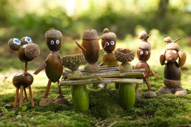 Photo of Cute figures made of natural materials on green moss outdoors