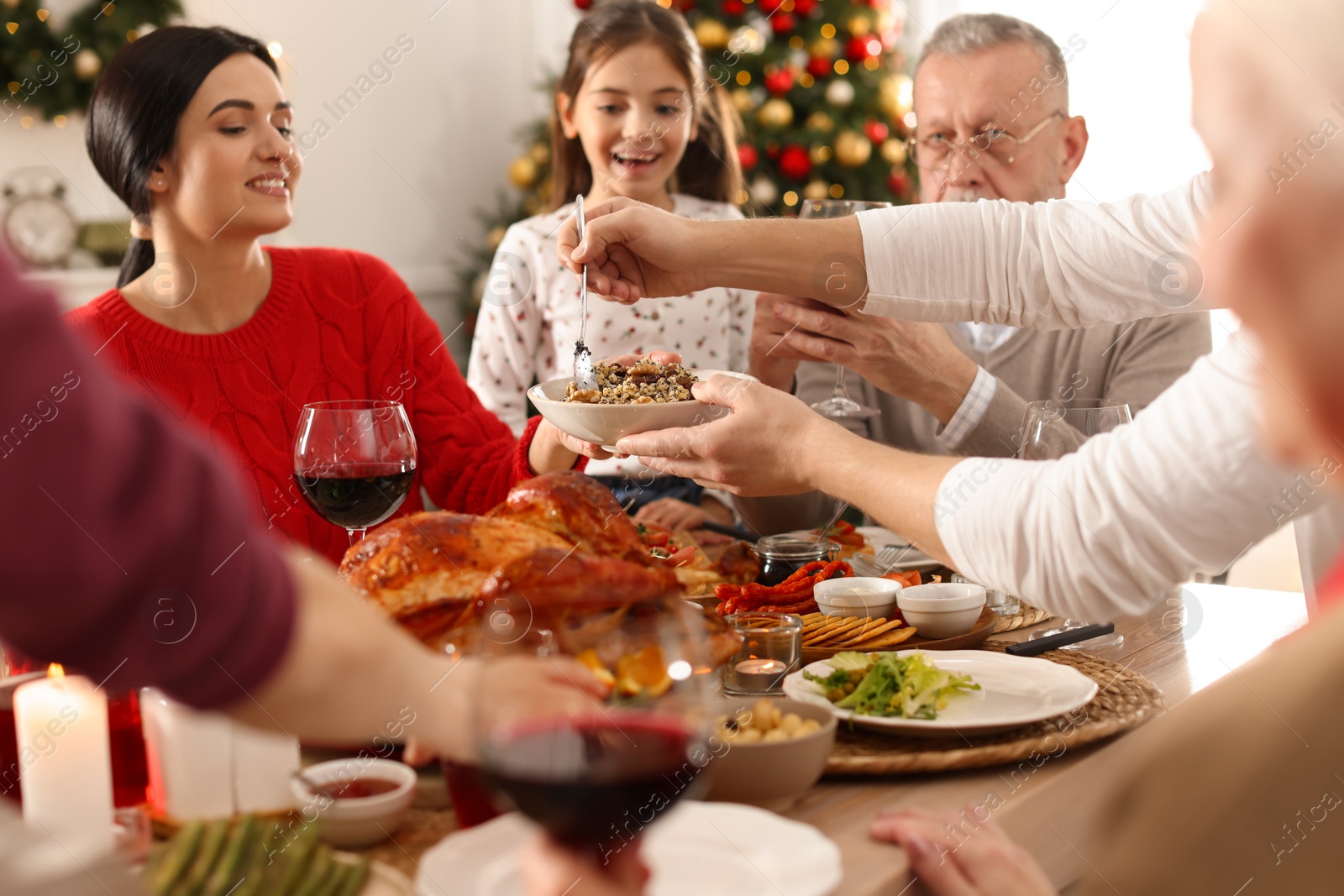 Photo of Man with bowl of traditional Christmas kutia and his family at festive dinner, closeup. Slavic dish