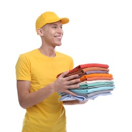 Photo of Dry-cleaning delivery. Happy courier holding folded clothes on white background