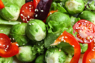 Tasty salad with Brussels sprouts as background, closeup