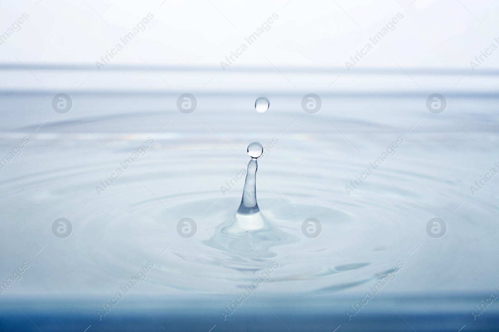 Photo of Splash of water with drops on white background