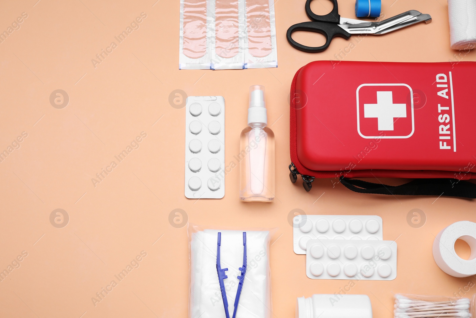 Photo of Flat lay composition with first aid kit on pale coral background. Space for text