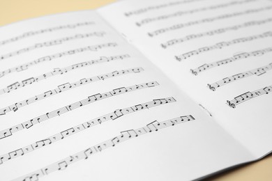 Photo of Sheet music book on beige table, closeup