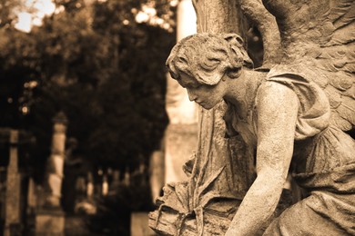 Image of Beautiful statue of angel at cemetery, space for text. Sepia tone