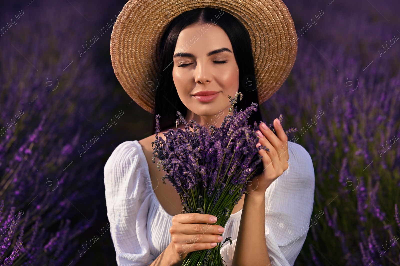 Photo of Beautiful young woman with bouquet in lavender field