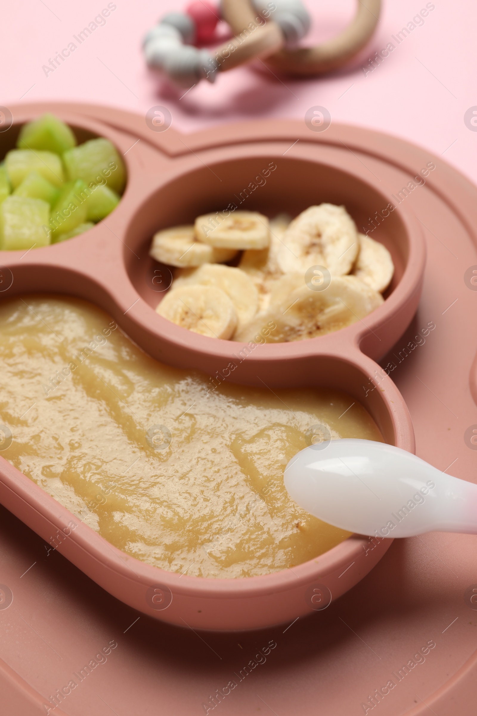Photo of Healthy baby food. Section plate with delicious apple puree, vegetables and fruit on pink background, closeup